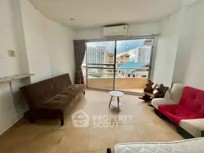 Spacious living room with modern furniture and city view balcony in urban apartment.