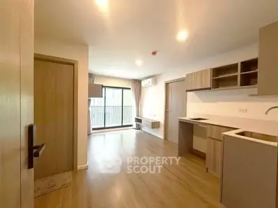 Modern open-layout apartment with wooden flooring and balcony access.