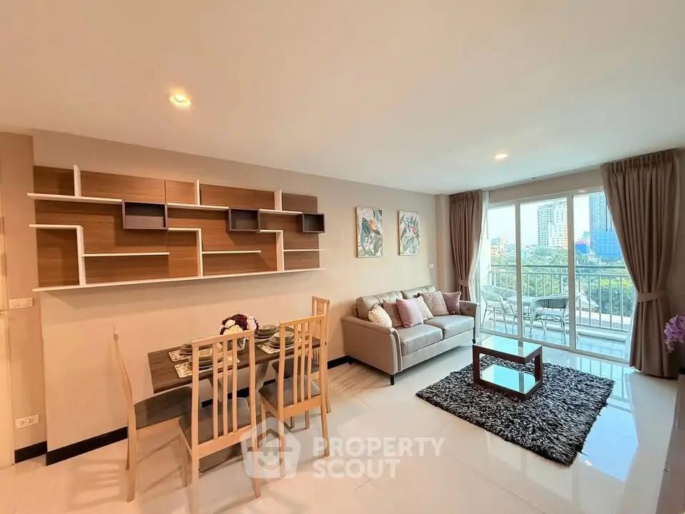 Modern living room with stylish decor and city view balcony in a high-rise apartment.