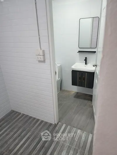 Modern bathroom with sleek black vanity and white brick tiles