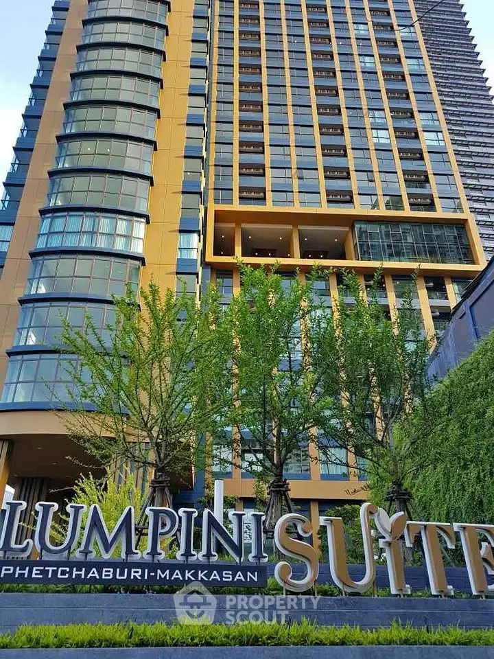 Modern high-rise building Lumpini Suite with lush greenery in Phetchaburi-Makkasan area.