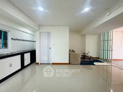 Spacious open-plan living area with modern kitchen and cozy seating, perfect for entertaining.