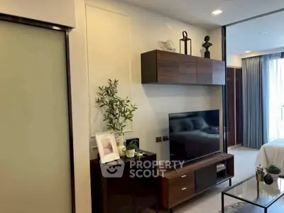 Modern living room with sleek TV unit and stylish decor in a cozy apartment setting.