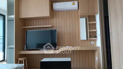 Modern living room with wooden paneling and sleek TV setup