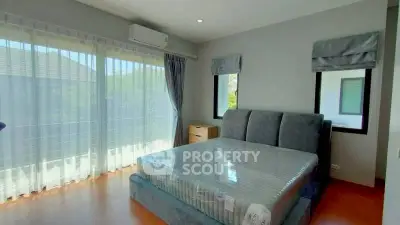 Spacious bedroom with large windows and modern furnishings