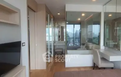 Modern apartment interior with wooden flooring and large windows offering city views.