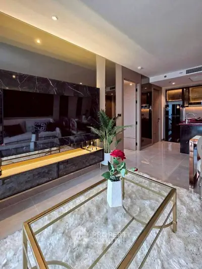 Luxurious living room with modern decor and open kitchen layout, featuring elegant furnishings and ambient lighting.