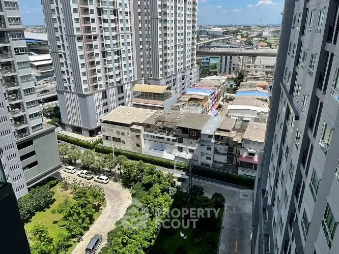 High-rise urban apartment view with lush garden and cityscape backdrop.