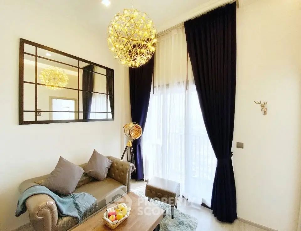 Elegant living room with modern chandelier, plush sofa, and floor-to-ceiling windows with dark curtains.
