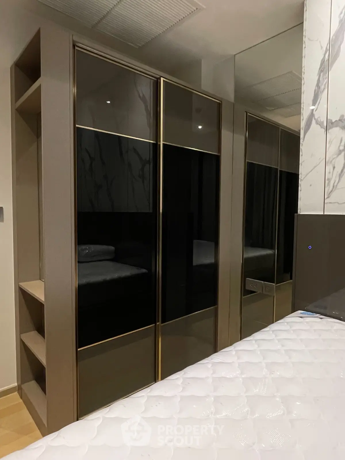 Modern bedroom with sleek mirrored wardrobe and stylish decor