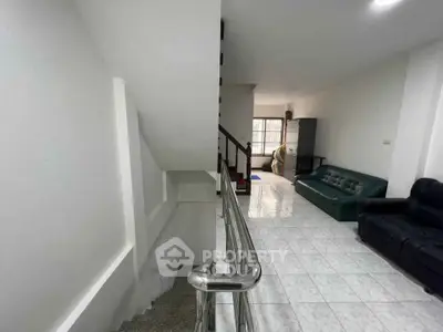 Spacious living area with modern staircase and tiled flooring