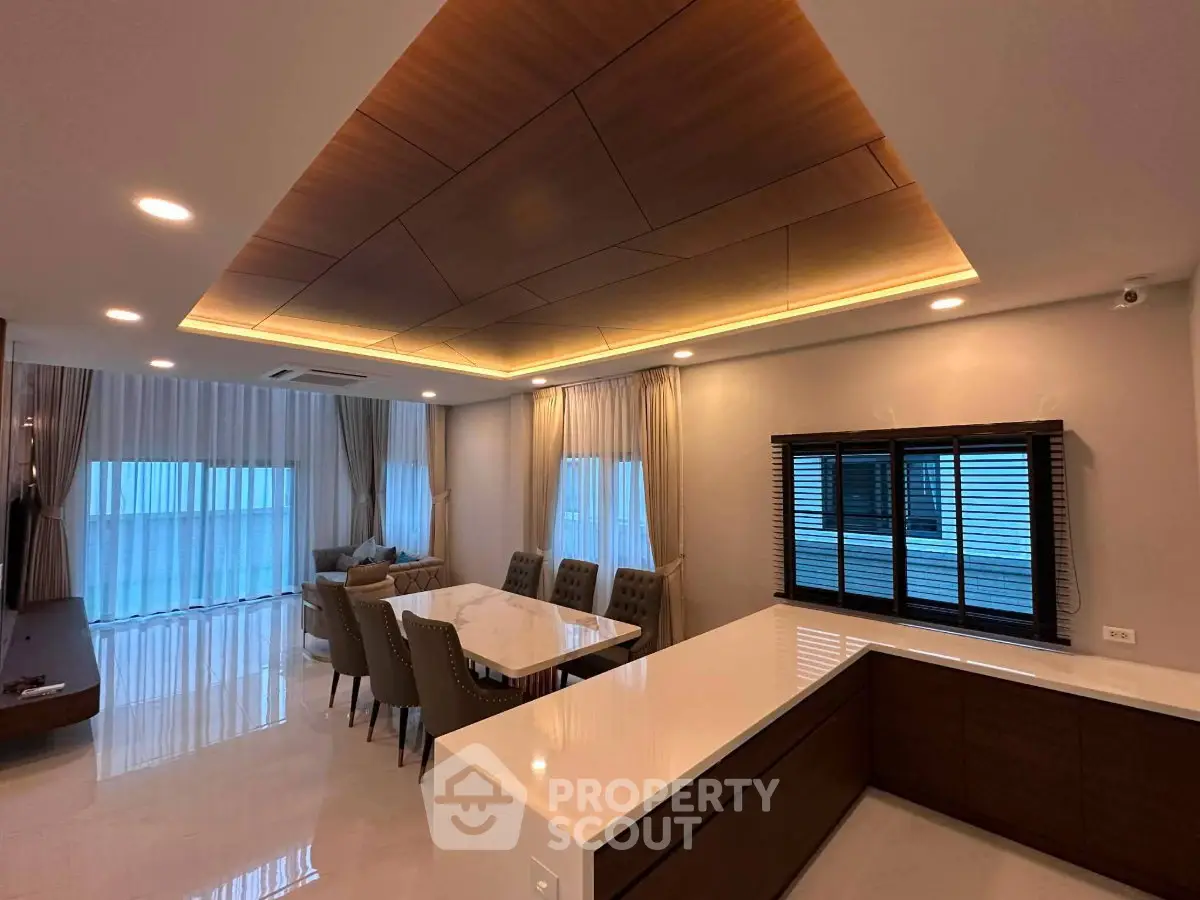 Luxurious open-plan living and dining area with modern lighting and elegant furnishings.