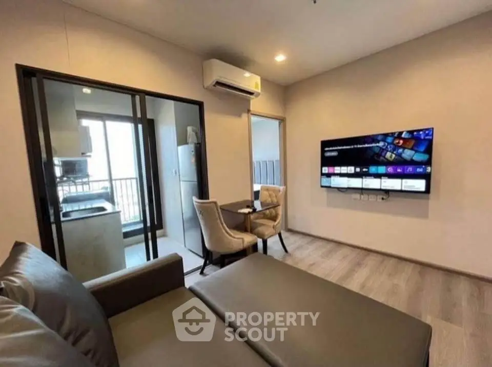 Modern living room with sleek furniture and wall-mounted TV in a stylish apartment.