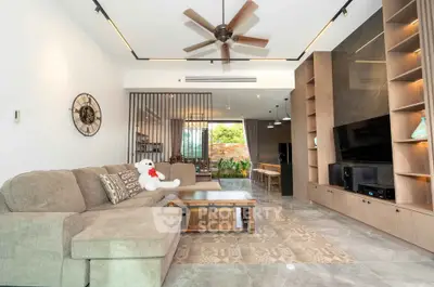 Spacious modern living room with elegant decor and open layout, featuring a large sectional sofa and stylish ceiling fan.