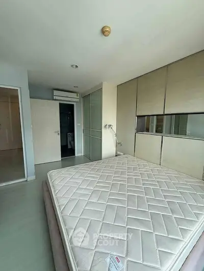 Spacious bedroom with modern design and ample storage in a stylish apartment.