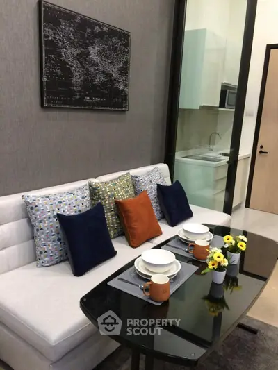 Stylish modern living room with cozy sofa, dining table, and chic decor in a compact apartment setting.