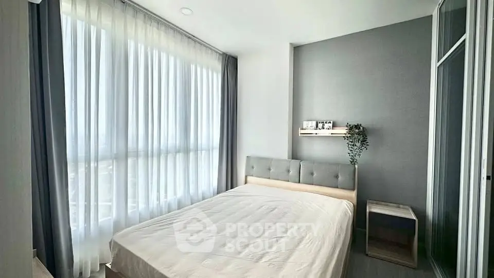 Modern bedroom with large windows and stylish decor in a contemporary apartment.