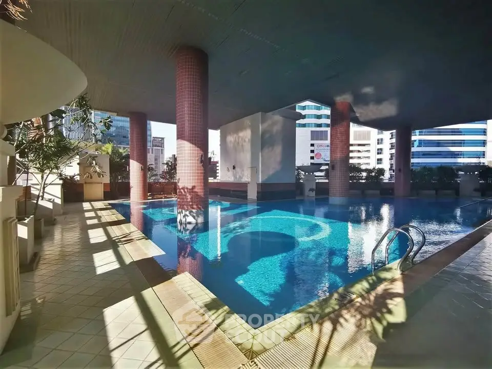Luxurious indoor pool area with modern architecture and city views, perfect for relaxation and leisure.
