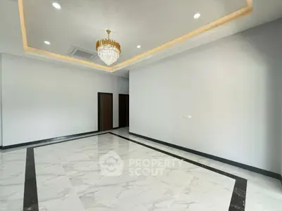 Spacious modern living room with elegant chandelier and marble flooring.