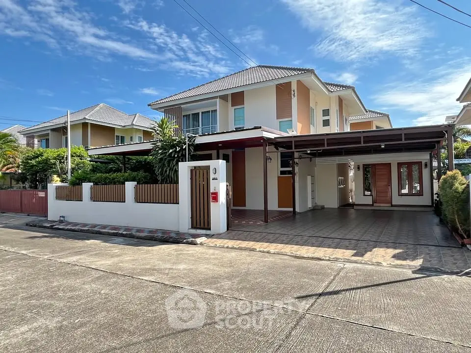 Stunning modern two-story house with spacious driveway and lush greenery in a serene neighborhood.