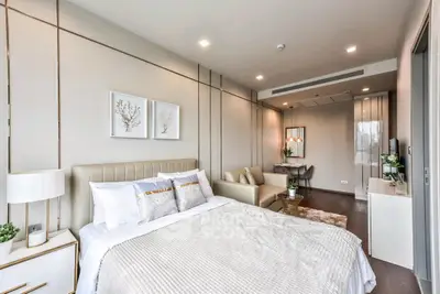 Luxurious modern bedroom with elegant decor and cozy seating area, perfect for relaxation and comfort.