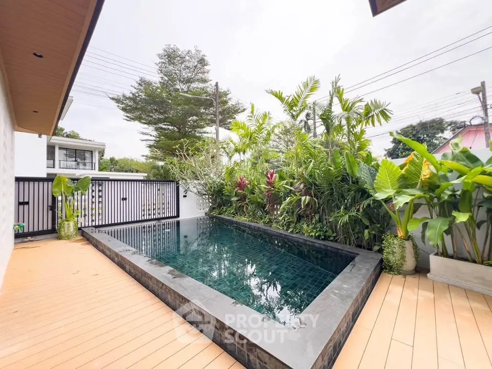 Stunning private pool surrounded by lush greenery and modern deck