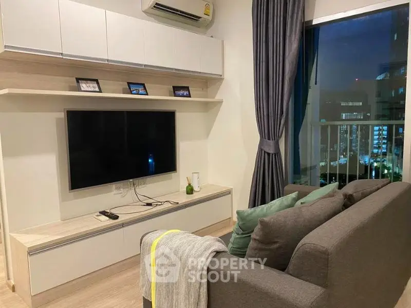 Modern living room with sleek TV setup and city view from window