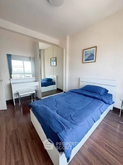 Cozy bedroom with blue bedding and mirrored wardrobe in modern apartment