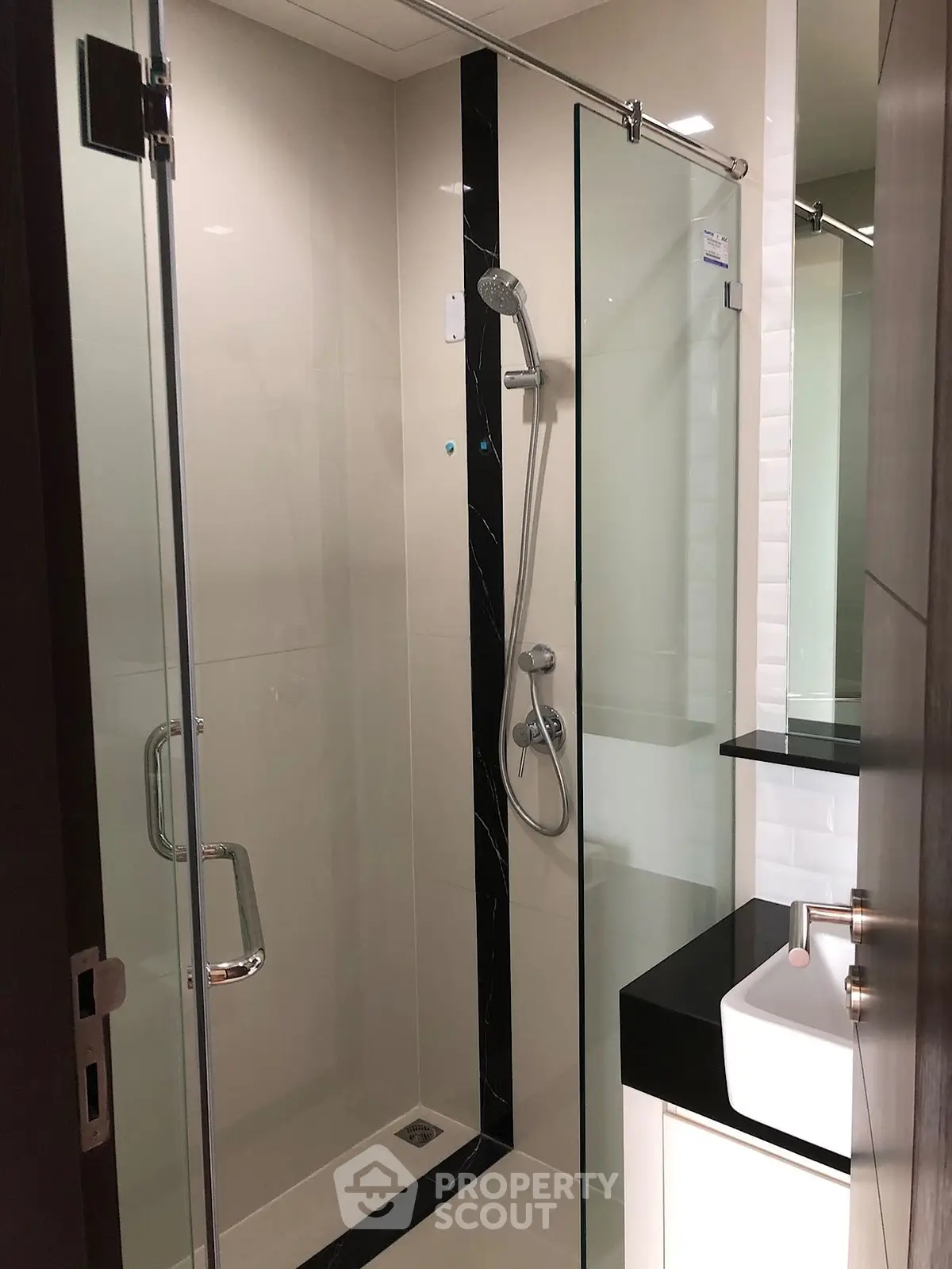 Modern bathroom with glass shower enclosure and sleek fixtures