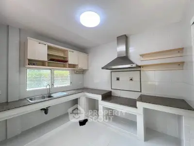 Modern kitchen with sleek countertops and stainless steel range hood