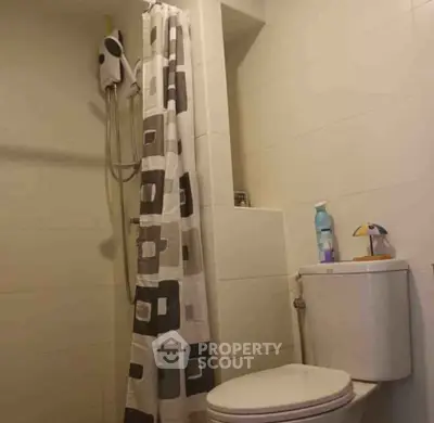 Compact bathroom with shower and modern fixtures in cozy apartment.