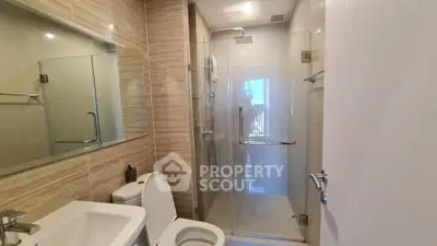 Modern bathroom with glass shower and sleek fixtures in a contemporary apartment.