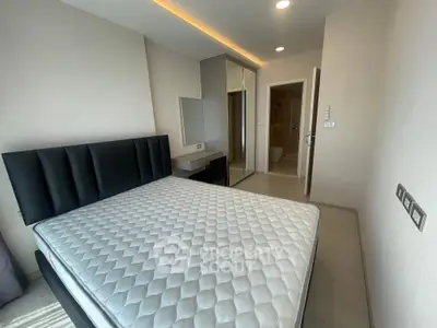 Modern bedroom with sleek design, featuring a comfortable bed and built-in wardrobe, perfect for urban living.
