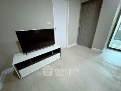 Modern living room with sleek TV stand and wooden flooring in a stylish apartment.