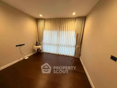 Spacious empty room with elegant curtains and wooden flooring