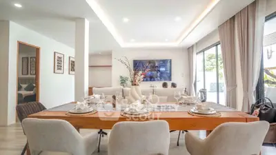 Spacious modern living room with elegant dining area and large windows.