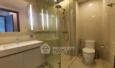 Modern bathroom with glass shower and sleek fixtures in luxury apartment.