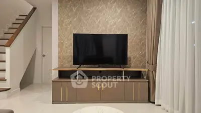 Modern living room with stylish TV stand and elegant staircase