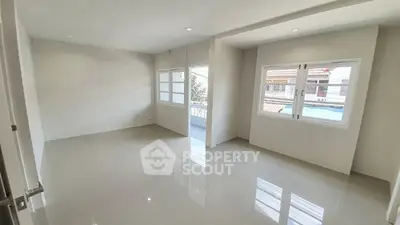 Spacious and bright living room with large windows and glossy tiled floor.