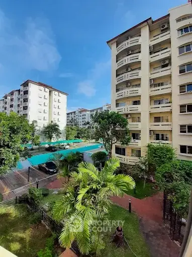 Stunning view of residential buildings with lush greenery and pool area.