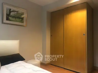 Cozy bedroom with wooden wardrobe and framed artwork