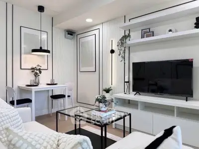 Modern living room with sleek decor, wall-mounted TV, and stylish dining area.
