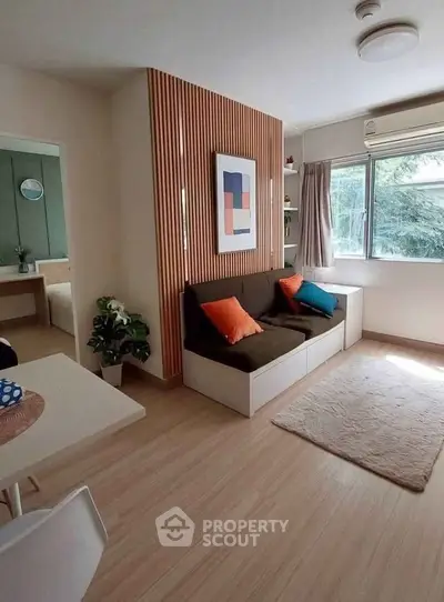 Modern living room with stylish decor and natural light, featuring cozy seating and wooden accents.