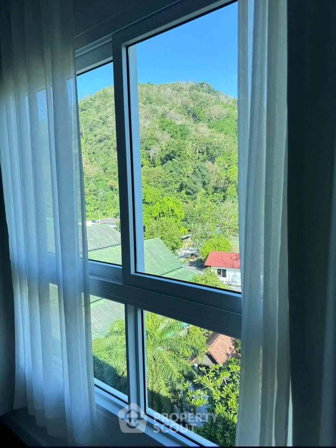 Stunning window view of lush green hills from a cozy interior, perfect for nature lovers seeking tranquility.