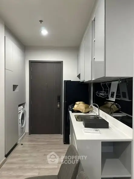 Modern kitchen with sleek cabinets and integrated appliances in a compact layout.