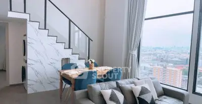 Stunning modern living room with city view, featuring elegant staircase and chic dining area.