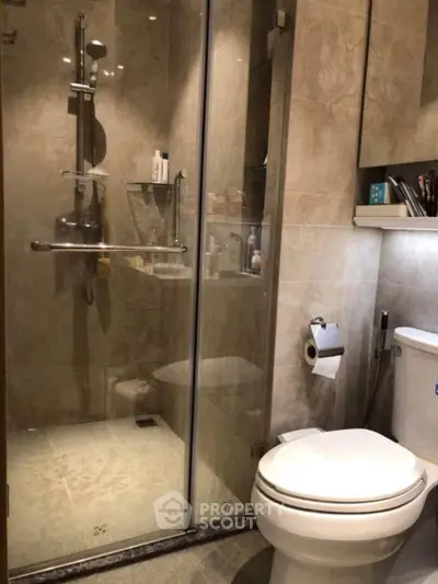 Modern bathroom with glass shower and sleek fixtures in a contemporary home.