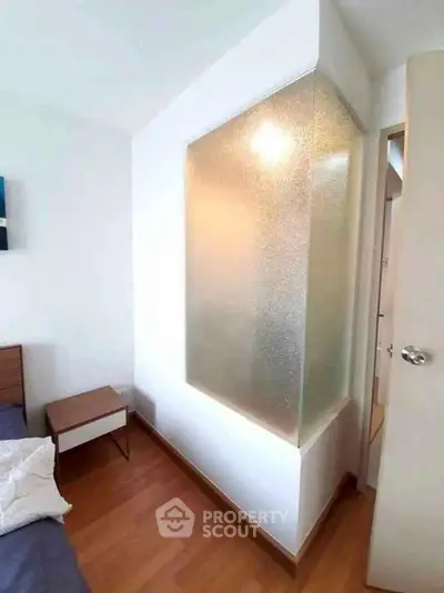 Cozy bedroom with frosted glass partition and wooden flooring