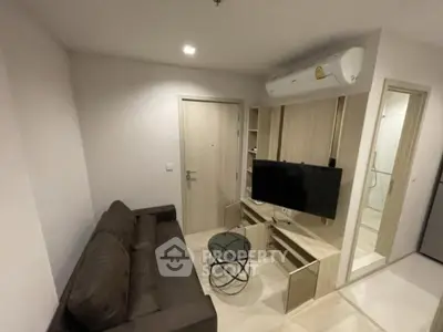 Modern living room with sleek furniture and wall-mounted TV in a cozy apartment.