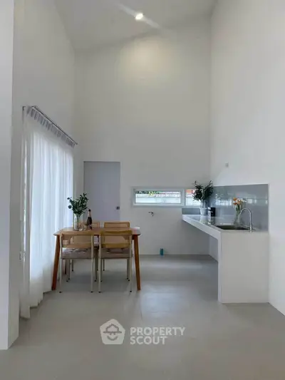 Modern minimalist kitchen with dining area and natural light